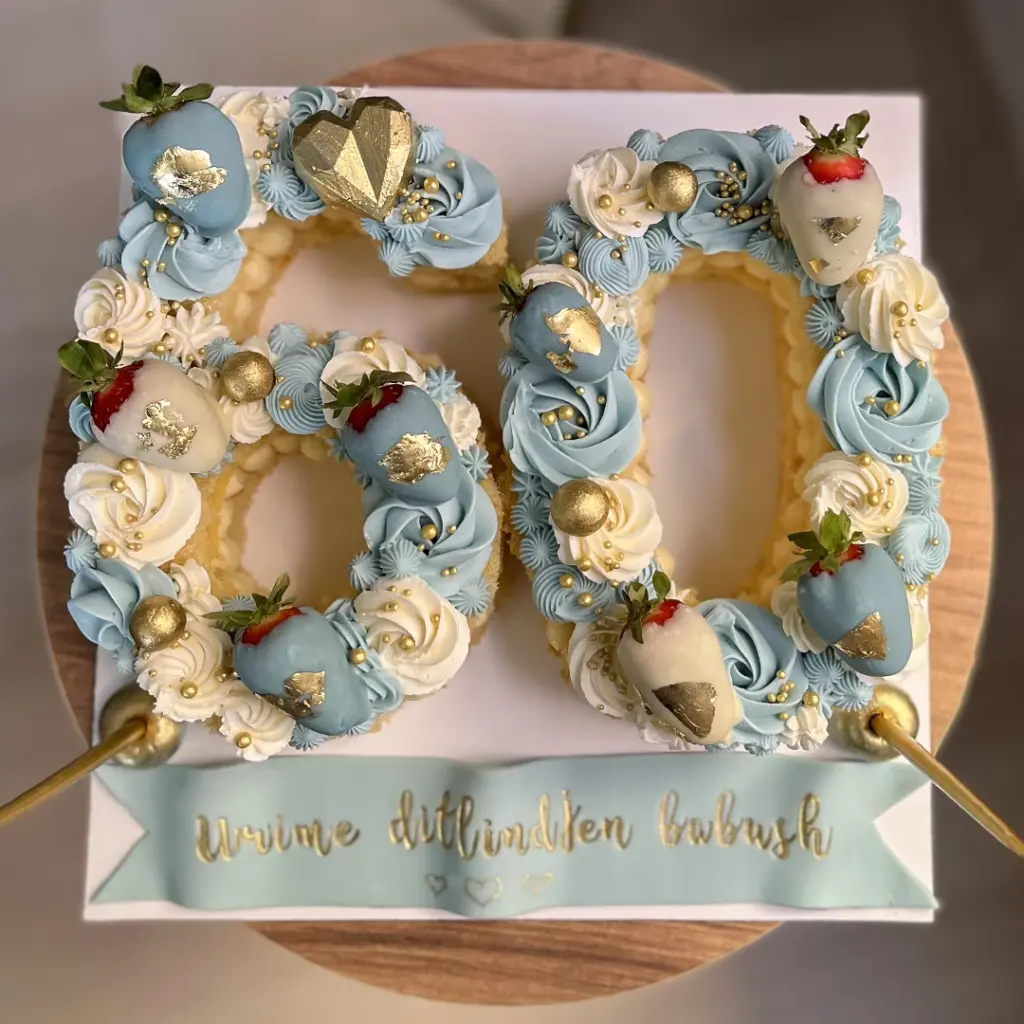 60 şeklinde, açık mavi ve beyaz kremalı, altın detaylı, çilekli ve Urime ditlindjen babush yazılı doğum günü pastası.